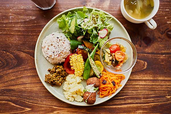 A plate of delicious vegan food set upon a wood grain table