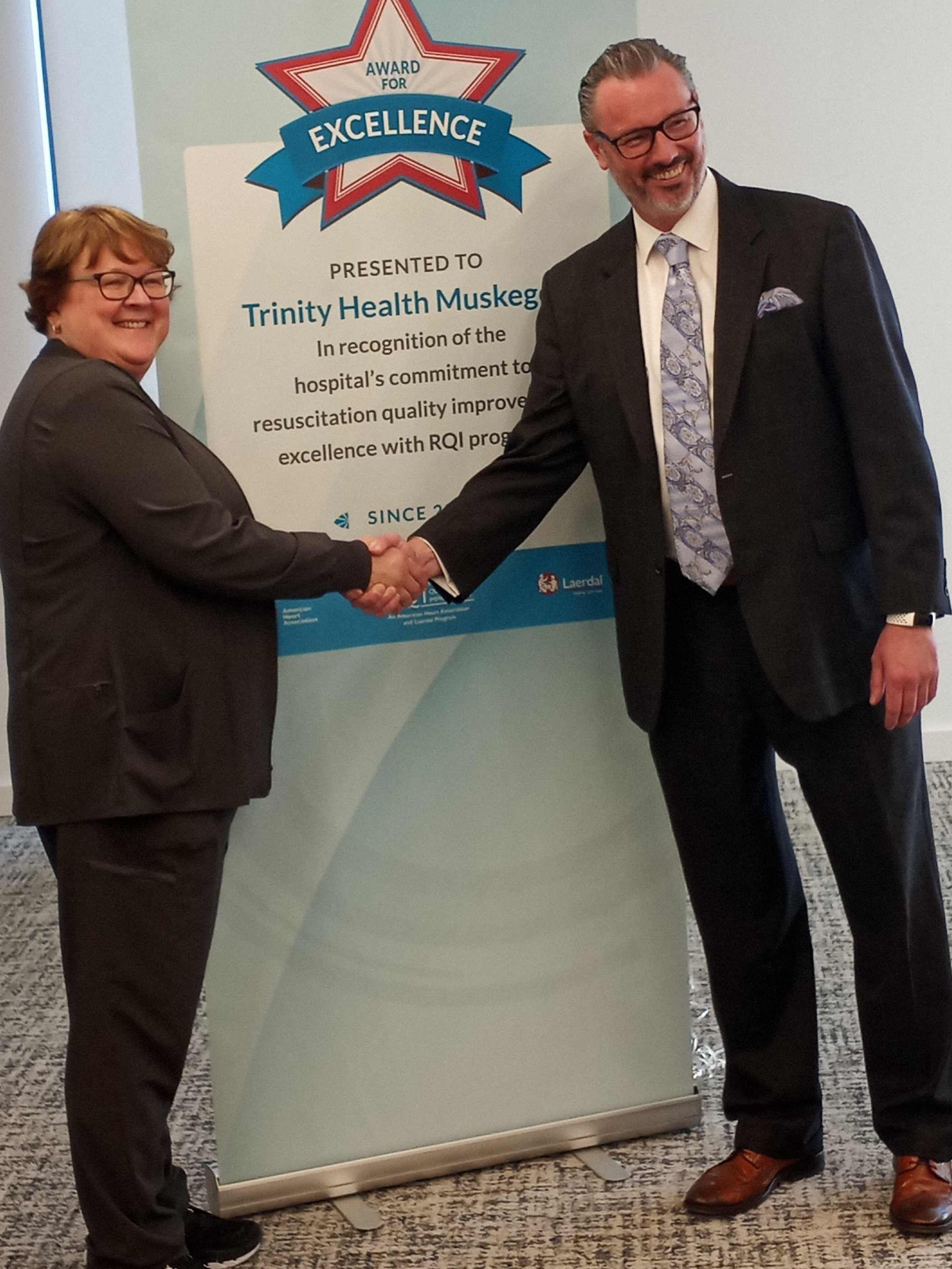 Matt Boisclair of RQI Partners presents Linda Dunmore, CNO of Trinity Health Muskegon, with Excellence Award